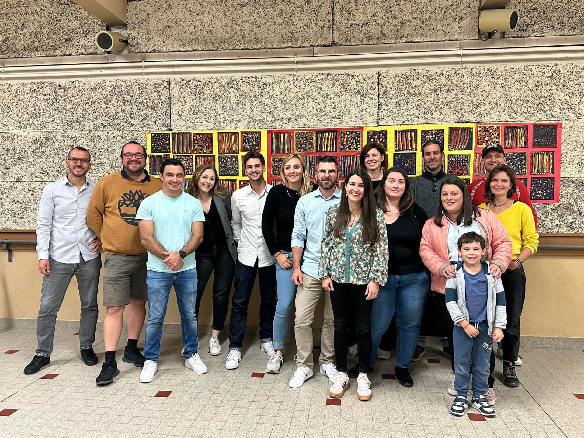 L'équipe bénévole de l'amicale réunie : parents et membres posant ensemble dans une salle de l'école